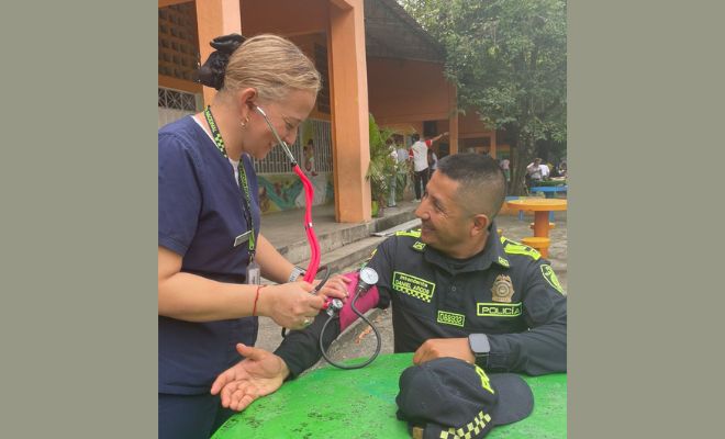 Una profesional médica realiza un chequeo a un policía durante la jornada electoral