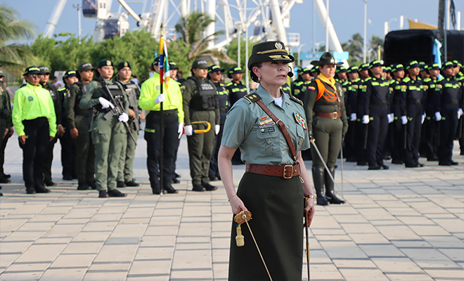 Oficial de la Policía Nacional con uniforme de gala realiza un saludo protocolario durante la ceremonia de transmisión de mando de la Policía Metropolitana de Barranquilla.
