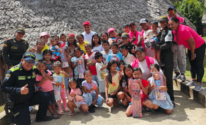 Tres policías y, a los lados de ellos, varios niños de pie junto a funcionarios públicos