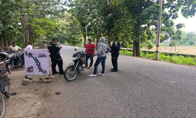 dos uniformados de la Policía nacional realizando  registro en vía publica  