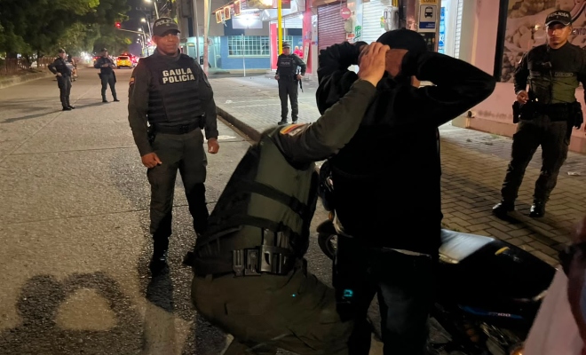 Grupo de funcionarios policiales en actividades de control realizando registro a persona a un ciudadano 