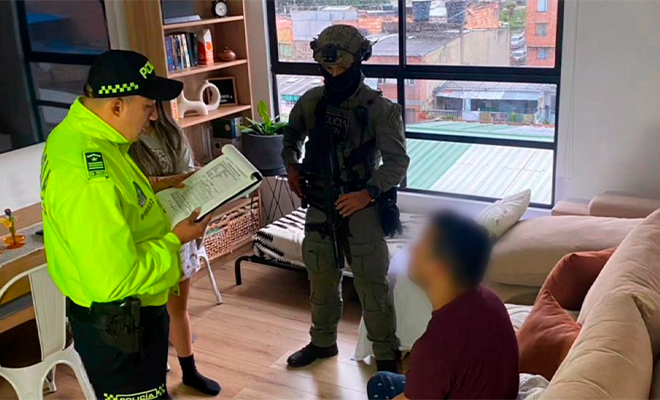 Funcionario de Policía Judicial realiza lectura de derechos de capturado a persona capturada.