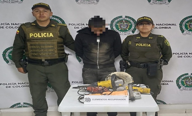 dos uniformados policiales y en el centro de la foto un hombre detenido, con elementos recuperados 