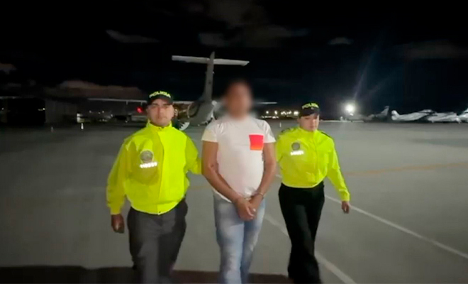 Dos funcionarios de Policía se desplazan con una persona capturada