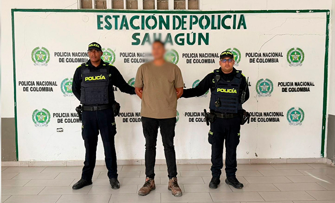 Capturado con fines de extradición es custodiado por dos policías en el backing.