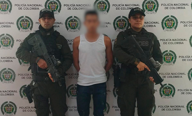 Dos integrantes de la policía custodian a un capturado