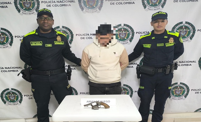 Dos funcionarios policiales y un capturado en el centro de la imagen 