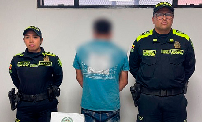 Persona capturada vestida con camiseta azul junto a dos uniformados de la Policía Nacional