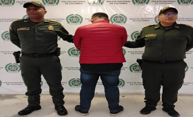 Dos funcionarios policiales, y un capturado de espaldas dos funcionarios policiales, y un capturado de espaldas 