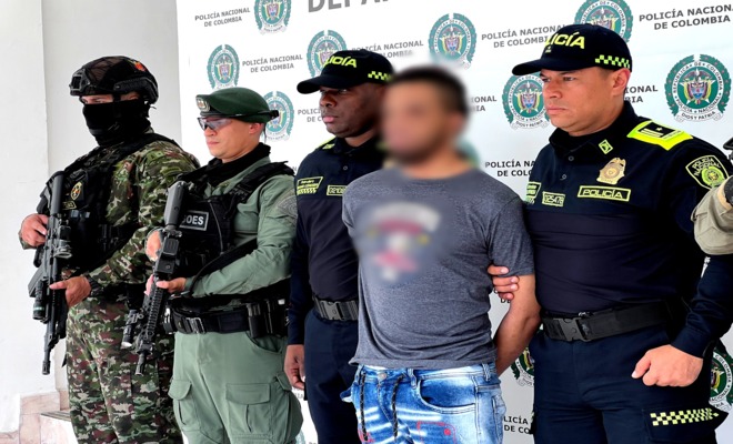 Dos soldados, un polic&iacute;a del GOES y dos polic&iacute;as custodian a un capturado