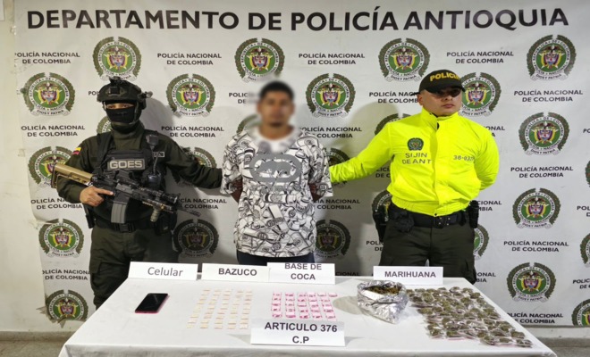 Policías de SIJIN y GOES custodian a una persona capturada por estupefacientes.