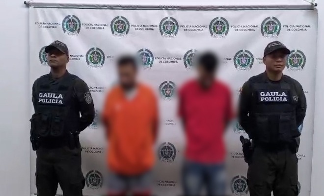 Dos Policías custodian a dos capturados