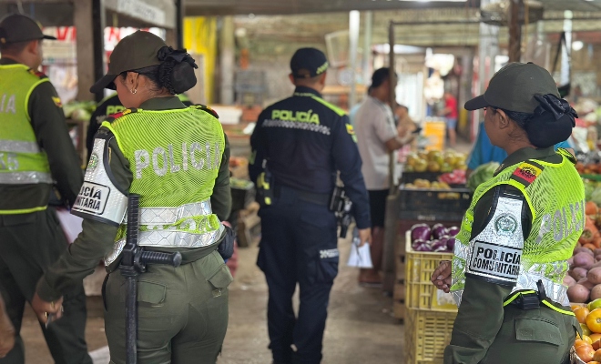 Cuatro funcionarios policiales en los pasillos del mercado del sur realizando actividad de acercamiento con los comerciantes 