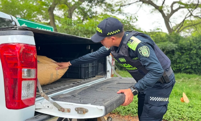 Funcionario policial realizando registro a vehículo en actividades de prevención  