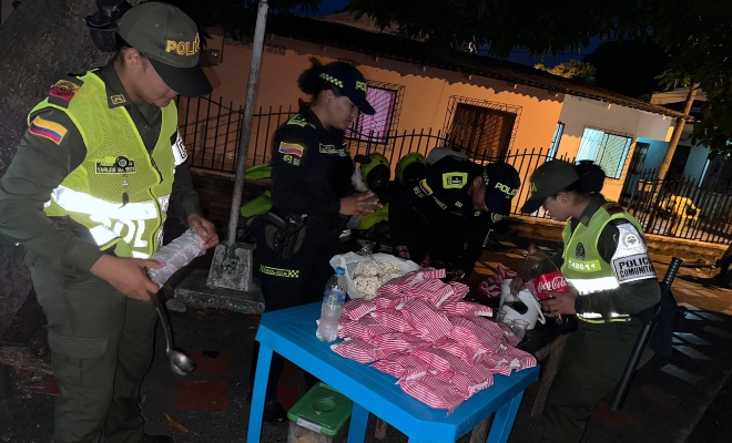 Cuatro funcionarios policiales organizando alimentos y bebidas para actividad de cine al barrio  