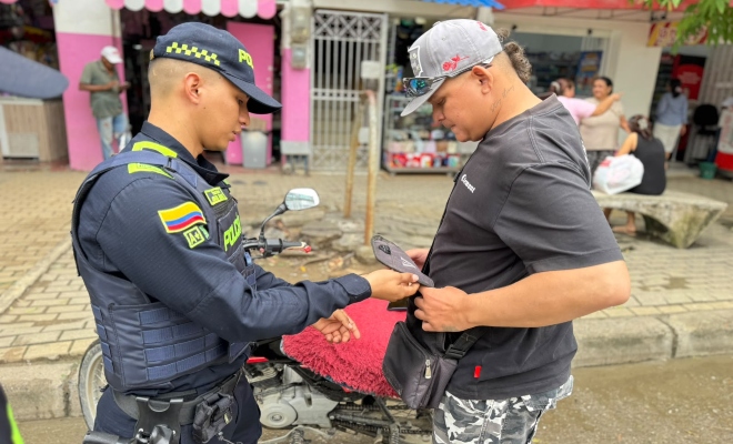 Funcionario policial realizando registro a un ciudadano en vía publica 