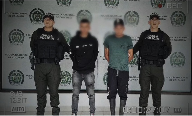 dos ciudadanos capturados, y dos polic&iacute;as a los lados 