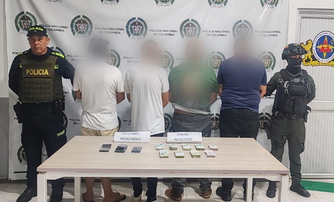 Cuatro capturados, dos polic&iacute;as y una mesa con objetos recuperados
