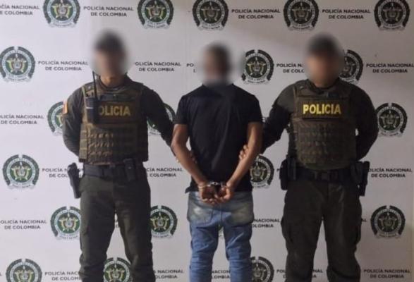 Dos policías junto a un capturado