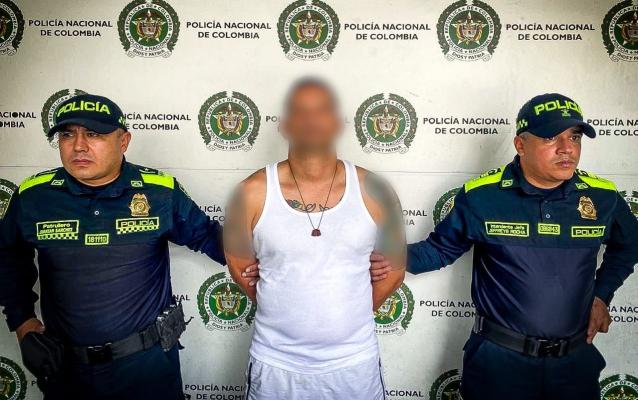 Dos policías presentan a un capturado conocido como alias Yesid.