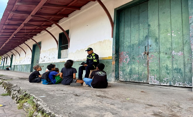 Un polic&iacute;a del grupo de infancia y adolescencia se encuentra realizando la lectura de un libro para unos ni&ntilde;os que lo acompa&ntilde;an 