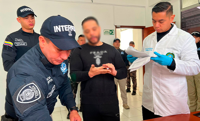 Funcionarios de Policía revisan la documentación de capturado para ser extraditado.