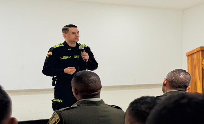 un señor oficial de la policía nacional impartiendo consignas a un personal uniformados 