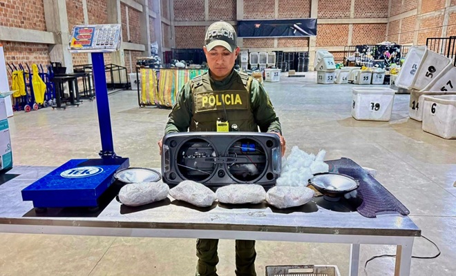 Un funcionario policial, una mesa con incautación base de coca 