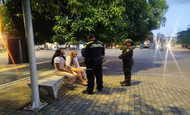 Dos policías realizando charla a dos ciudadanas 