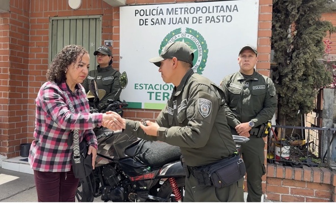 Tres policías en la Estación de Policía Terminal entregando las llaves a una ciudadana 