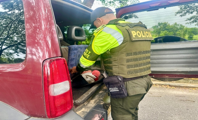un uniformado revisando el kit de carretera  de un vehículo 