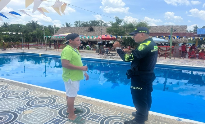 uniformado realizando charla preventiva sobre de prevención, inspección y control en los centros recreacionales 