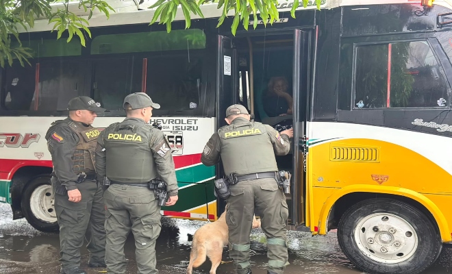 tres uniformados de la policía nacional y un canino solicitando registro a personas 