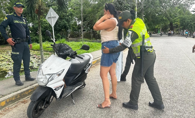 dos uniformados de la Policía Nacional  realizando registro a persona en vía publica 