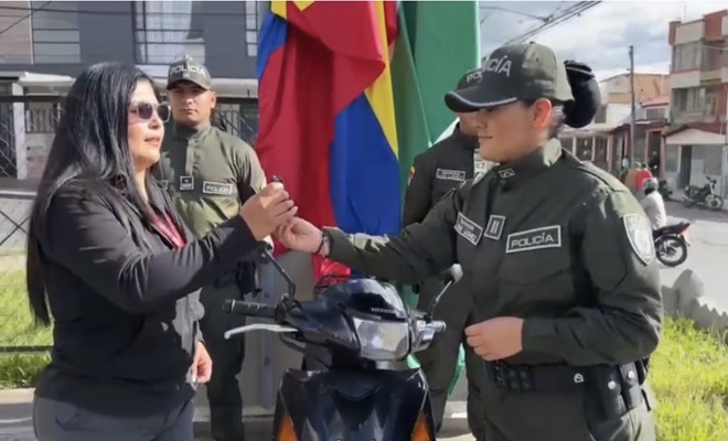 4 personas, a lado izquierdo de la imagen una ciudadana recibiendo la llave por parte de una funcionaria policial y en la parte posterior de la imagen dos funcionarios policiales