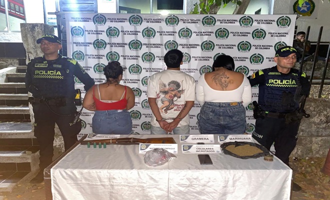 Policías custodian tres personas capturadas en la mesa elementos incautados 