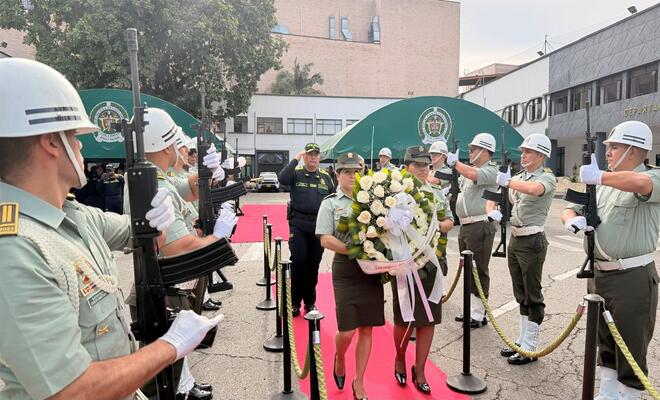 Policías uniformados con una ofrenda floral