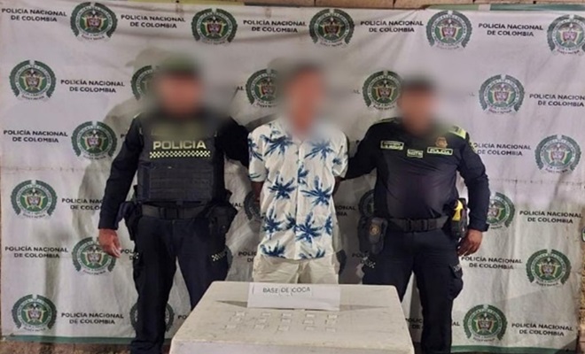 Polic&iacute;as, comunidad y una mesa con bolsas de estupefacientes