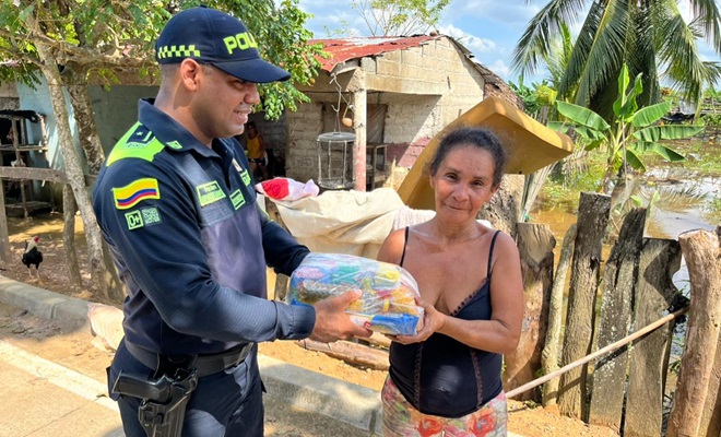 Polic&iacute;a entregando un mercado a una ciudadana