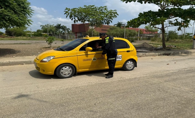 Un polic&iacute;a saludando a un taxista en controles 