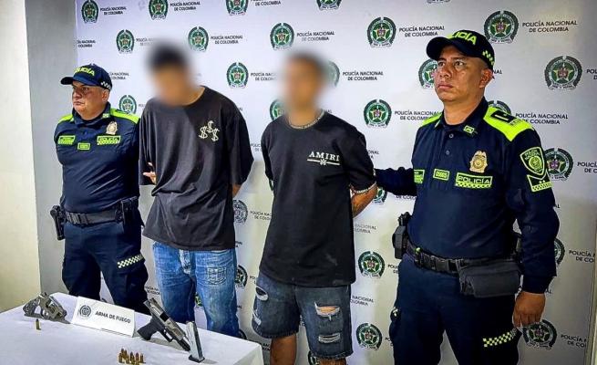Dos policías con  dos personas Capturadas y armas de fuego incautadas