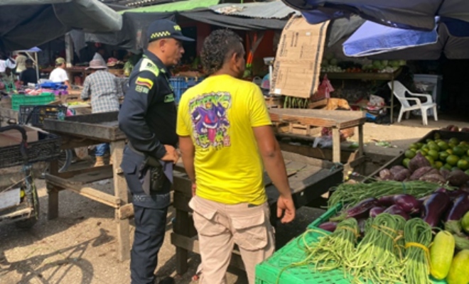Un funcionario policial y un ciudadano en el mercado de la ciudad