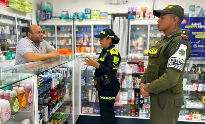 Dos funcionarios policiales con un ciudadano brindando recomendaciones de seguridad en establecimiento de comercio