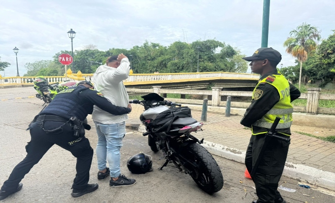 dos uniformados realizan registro a personas en v&iacute;a publica a un ciudadano y una motocicleta