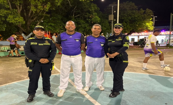 dos uniformados con dos ciudadanos en una cancha  en la ciudad de montería