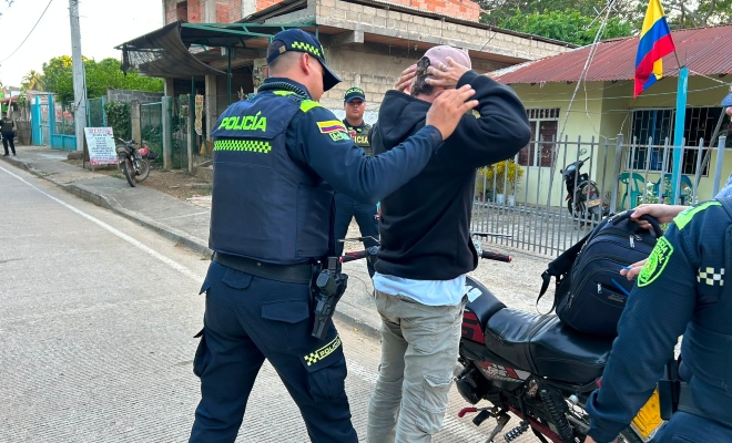 Dos funcionario policiales realizando registro a persona a un ciudadano en vía pública