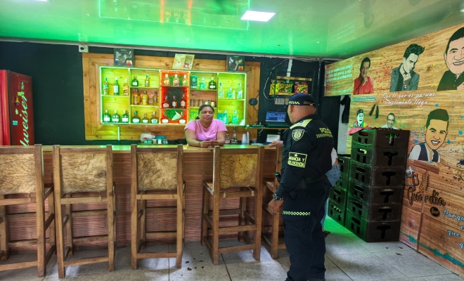 un uniformado de la policía nacional con una  ciudadana en establecimiento abierto al publico 
