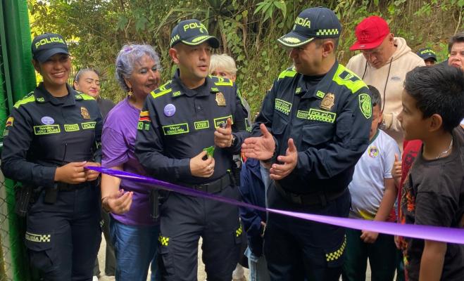 Policías y comunidad cortan el listón durante la reinauguración de la escuela rural.