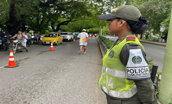 una uniformada de la policía nacional prestando seguridad en la ciclorruta