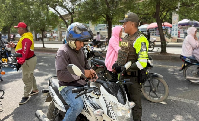 un policía de transito y transporte con un ciudadano  brindando tips de seguridad al ciudadano 